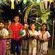 Children in traditional dress holding krathong under a lantern arch at night during Loy Krathong at The Bush Camp Chiang Mai